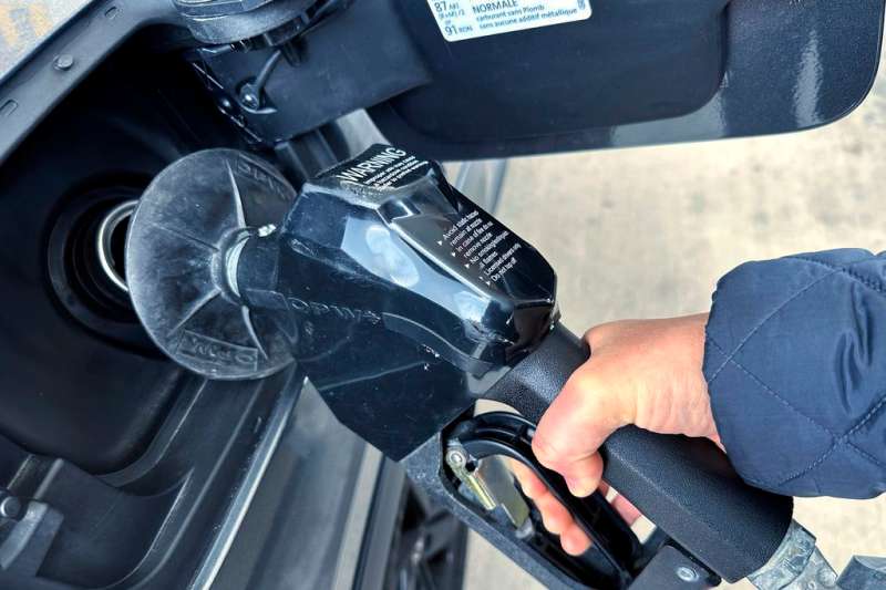 A custumer pumps gas at a gas station.