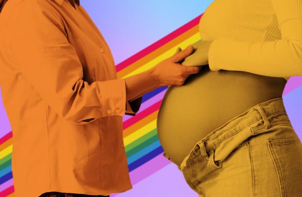 Someone holding a pregnant women's hand with a rainbow in the background.