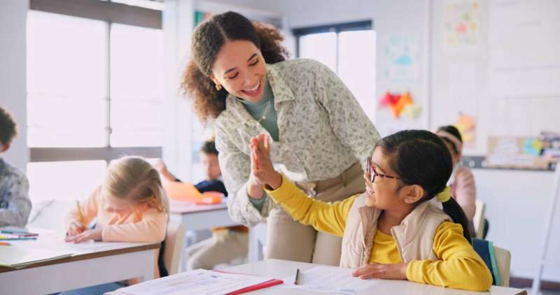 Teacher woman, high five girl and classroom with achievement, success and mentorship for learning. Education, development and students with goals, knowledge and books with celebration at school desk