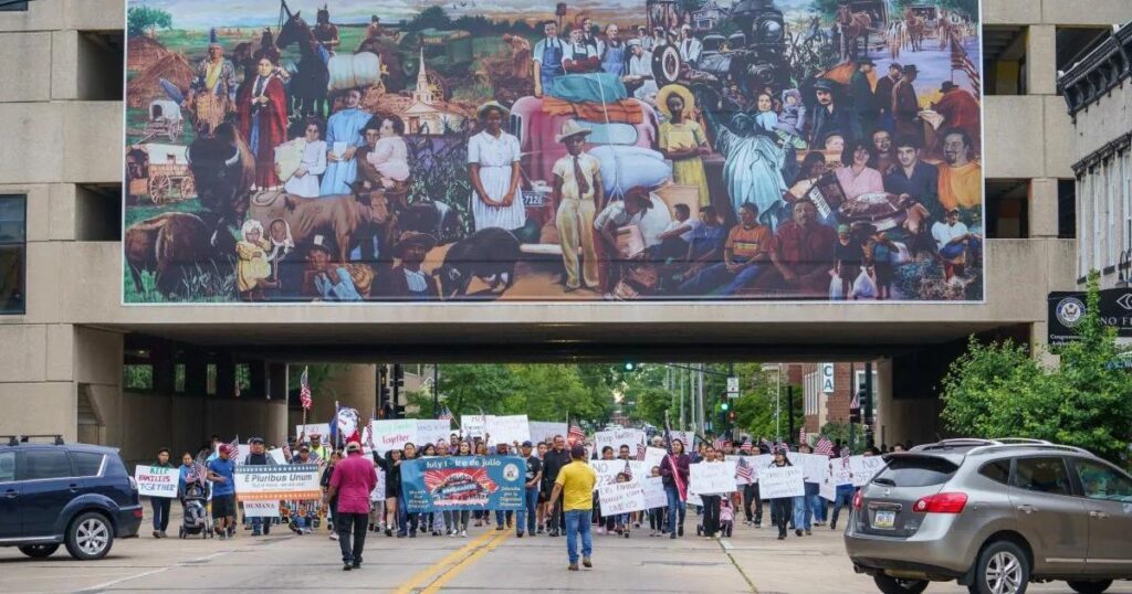 Residents marched from Queen of Peace Parish to Lincoln Park to protest Iowa's new immigration law, which would criminalize being in the state without documentation, in Waterloo, Iowa, on July 1, 2024. photo by Eric Benson, for Investigate Midwest