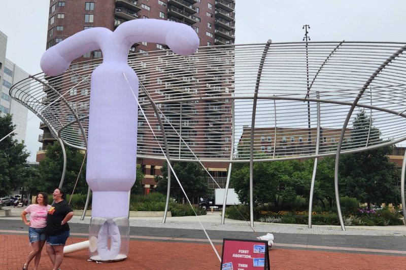 A 20-foot tall lavendar-colored inflatable IUD stands in Cowles Commons in downtown Des Moines.