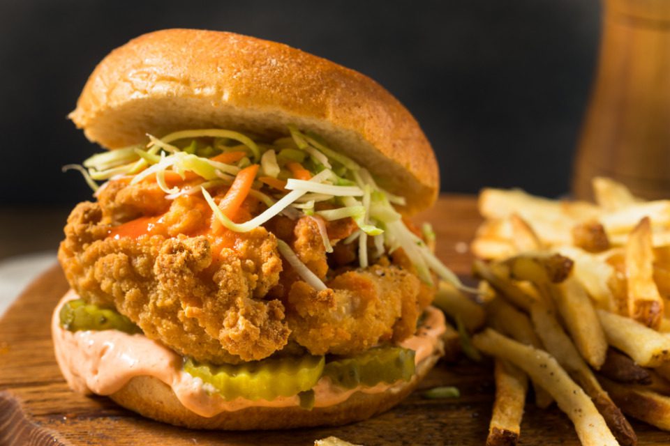 A fried chicken sandwich with french fries.