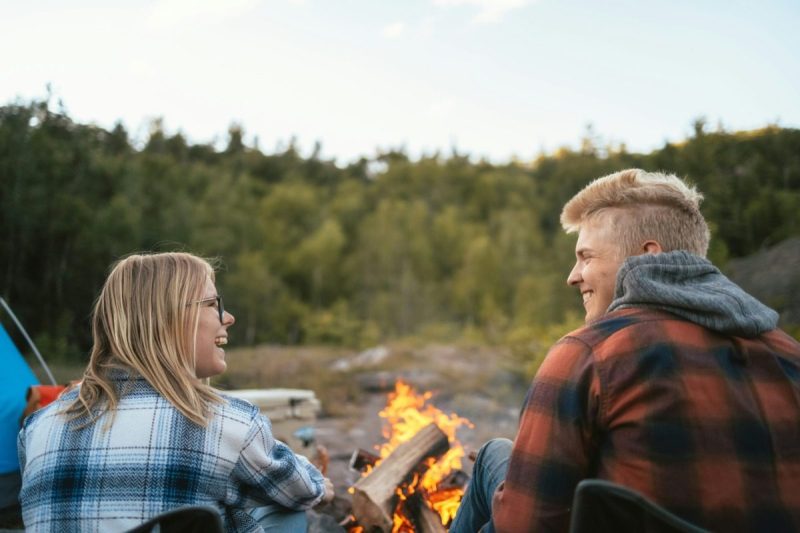 couple smiling before campfire