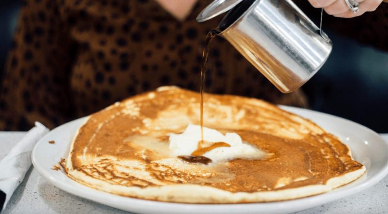 syrup being poured over pancakes at a diner in iowa