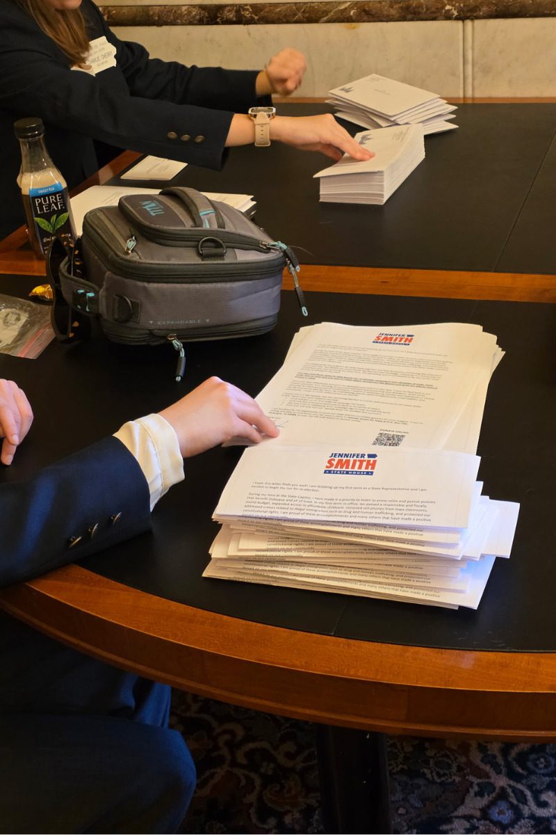 Iowa House legislative pages pack reelection mailers for Iowa Rep Jennifer Smith on April 6, 2026 in the House Lobbyist Lounge at the Iowa State Capitol.